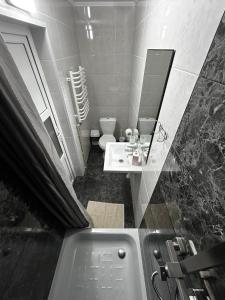 uma casa de banho com uma banheira, um lavatório e um WC. em Зоряні Карпати em Slavske