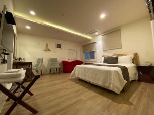 a bedroom with a large bed and a red couch at Kenting Heng-Chung Art Hostel in Hengchun +34 photos