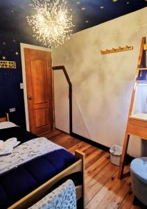 オクサパンパにあるLa casa del Erizoのベッドルーム1室(ベッド1台、シャンデリア付)