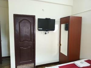 a room with a door and a tv on the wall at Hotel Royal Green Inn in Chennai