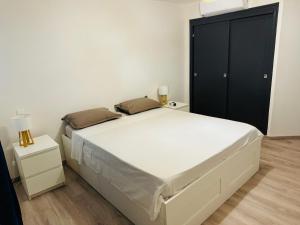 - une chambre avec un grand lit et une armoire noire dans l'établissement T3 COSY - quartier Hauts Vallons, à Mamoudzou