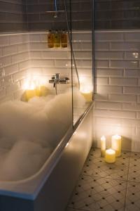 a bathroom with a bath tub with candles in it at Aparthotel Amella in Riga