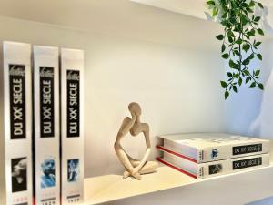 Uma prateleira com livros e uma boneca em cima deles. em Apartment Malaussena - Reception 24&7 - Center Libération em Nice