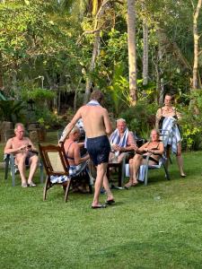 a shirtless man standing in front of a group of people at Hotel Heladiv in Anuradhapura