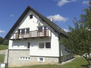 een wit huis met een balkon aan de zijkant bij Guesthouse Bor Plitvice Lakes in Plitvička Jezera