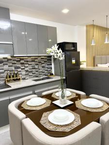 a kitchen with a table with white plates on it at Luxury Pad Near Clark Pampanga in Angeles