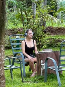 a woman in headphones sitting on a bench at Hotel Heladiv in Anuradhapura