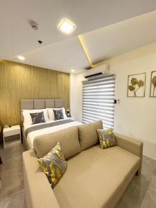 a bedroom with a bed and a couch at Luxury Pad Near Clark Pampanga in Angeles