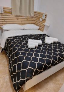 a large bed with a black and white comforter at MIRIS home fast and comfortable with self check in 8 minutes walk near Naples airport in Naples