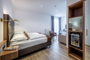 ein Schlafzimmer mit einem Bett und einem TV in einem Zimmer in der Unterkunft Hotel Nestroy Wien in Wien