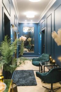 a lobby with blue walls and chairs and a mirror at Aparthotel Amella in Rīga