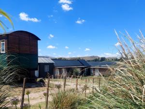 a barn with a silo in a field of grass at El Vagón in Sierra de la Ventana
