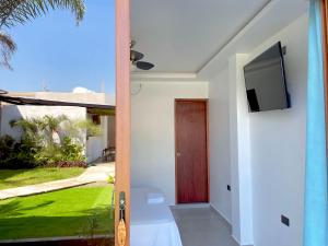 uma porta para uma casa com uma televisão na parede em Hotel Palmar Del Río em Pedernales