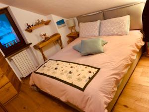 a bedroom with a bed with pillows and a television at mansardacourmayeur in Courmayeur