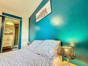 ベルク・シュル・メールにあるRénové Appartement à 30 m de la plage - balcon - lumineux - wifi - Le Cérès 2の青い壁のベッドルーム1室、ベッド1台が備わります。