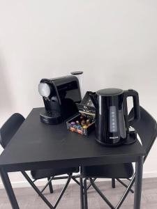 - une table noire avec une cafetière et une cafetière dans l'établissement Studio thème paris, à Gentilly