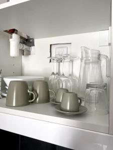 une étagère avec des tasses et des vases en verre dans l'établissement Studio thème paris, à Gentilly