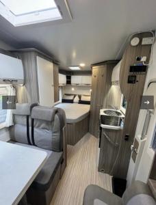 an interior of an rv with a bed and a kitchen at Zebra motorhome hire in Ravensworth