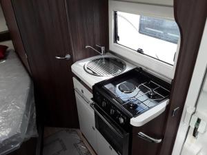 a small kitchen with a stove and a window at Zebra motorhome hire in Ravensworth