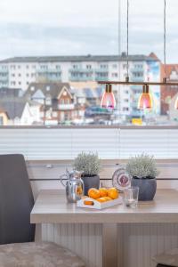 une table avec des oranges devant une fenêtre dans l'établissement Ferienwohnung mitten in Westerland mit Balkon, à Westerland