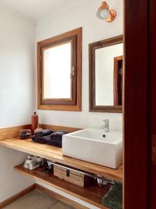 La salle de bains est pourvue d'un lavabo blanc et de deux miroirs. dans l'établissement El Cerrito departamento, à Tandil