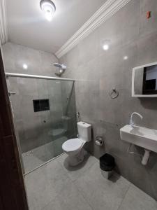 a bathroom with a shower and a toilet and a sink at Pousada Primeiro Sol in João Pessoa