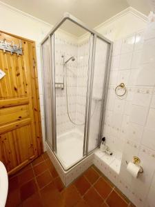 um chuveiro com uma porta de vidro na casa de banho em Hooger Wal 19 Morsumer Kliff em Morsum