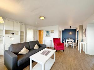 ein Wohnzimmer mit einem Sofa und einem Tisch in der Unterkunft Haus Metropol App 327 mit Meerblick und Cityblick 3 Balkone in Westerland