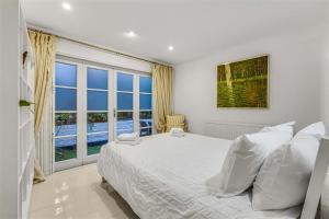 a bedroom with a bed and a large window at Earls Court Spacious Apartment in London