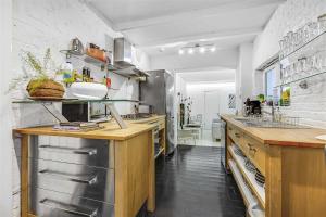 una grande cucina con banconi in legno ed elettrodomestici in acciaio inossidabile di Earls Court Spacious Apartment a Londra