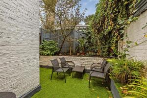 a group of chairs and tables in a yard at Earls Court Spacious Apartment in London