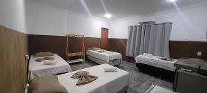 una habitación con 3 camas en una habitación de hospital en Pousada Primeiro Sol en João Pessoa