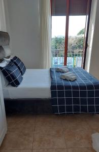 1 cama con toallas en una habitación con ventana en MIRIS home fast and comfortable with self check in 8 minutes walk near Naples airport en Nápoles