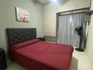 ein Schlafzimmer mit einem roten Bett und einem Fenster in der Unterkunft Casa Villa Carlos Paz, a 3 cuadras del río. Playas de Oro in Villa Carlos Paz