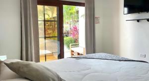 a bedroom with a bed and a sliding glass door at Hotel Palmar Del Río in Pedernales
