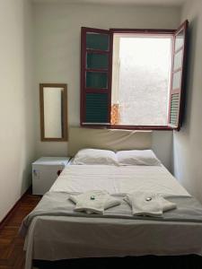 a bedroom with a bed with two towels on it at Casa do Alferes in Ouro Preto