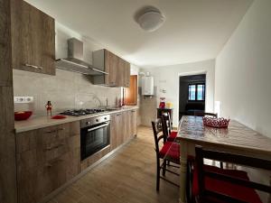 kuchnia z drewnianymi szafkami i stołem z krzesłami w obiekcie Red Cottage-Campo Felice w mieście Collimento