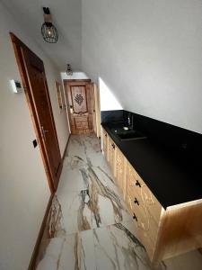 a kitchen with a marble floor and a sink at Rozeta in Witów