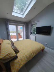 a bedroom with a bed with a window and a television at Lovely double room with en-suite bathroom in The Hyde