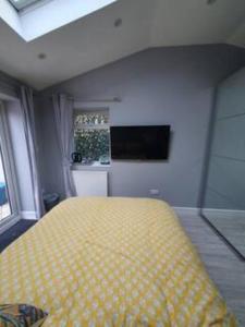 Un dormitorio con una cama amarilla y una ventana en Lovely double room with en-suite bathroom en The Hyde