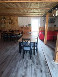 ein Esszimmer mit einem Holztisch und Stühlen in der Unterkunft Przystanek Rospuda in Sucha Wieś
