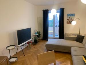 a living room with a couch and a flat screen tv at Apartment Grossman in Hradec Králové