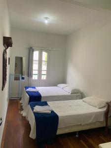 um quarto com duas camas com lençóis azuis em Casa próxima ao centro de convenções da UFOP em Ouro Preto
