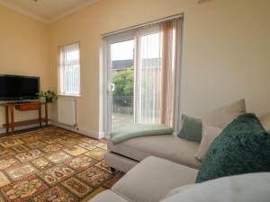 a living room with a couch and a tv at 2 Gladstone Avenue in Melton Mowbray