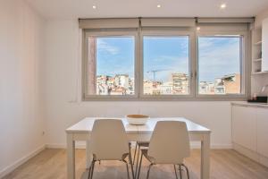 a kitchen with a table and two chairs and a window at BcnStop Sant Pau Suites in Barcelona