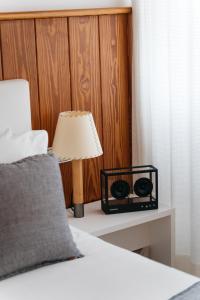 a bedroom with a bed with a lamp on a table at Hotel Casa Nereta in Cadaqués