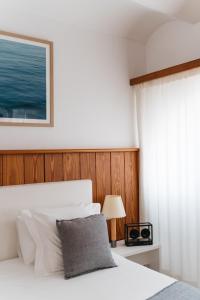 a bedroom with a white bed with a wooden headboard at Hotel Casa Nereta in Cadaqués