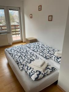 um quarto com uma cama com um cobertor azul e branco em Apartma Stenar em Mojstrana