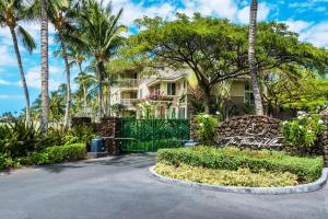 a house with palm trees and a gate at Fairway Villas Waikoloa A31 in Waikoloa