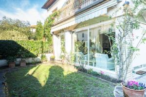 een huis met een tuin met stoelen en planten bij La Romantica Veranda Free Parking and Garden in Lucca